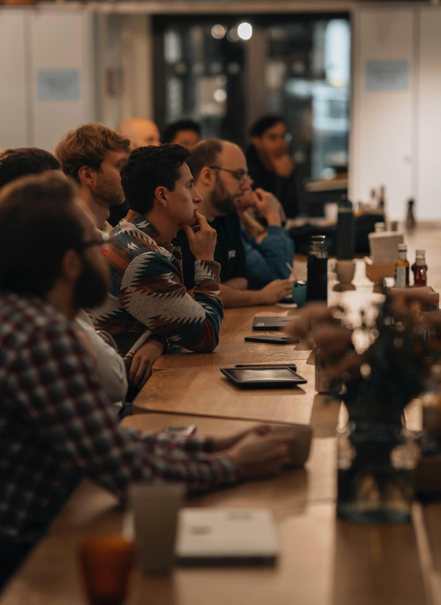 Adults attentively listening in a professional setting, ideal for business or education themes.